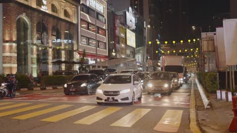 profile view of vehicles stopped at red signal during nighttime in kuala lumpur, malaysia.