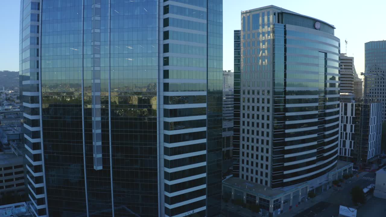 We look to the left as the buildings pass by during a beautiful sunrise morning shot of the city urban companies buildings during travel we see lens flares