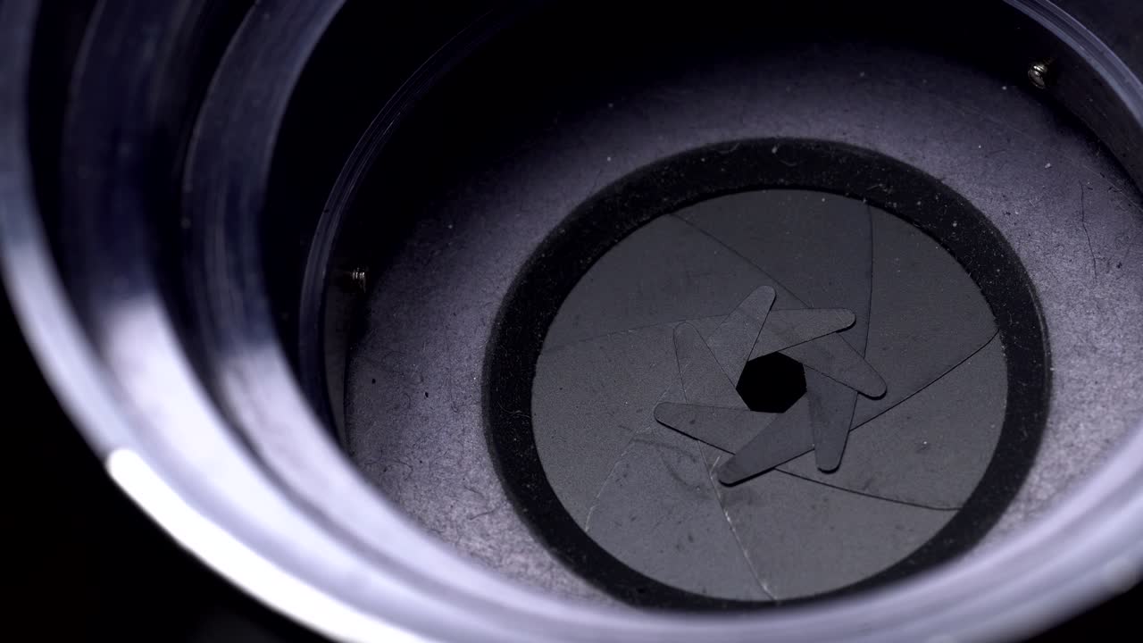 Aperture or iris mechanism in rotation. Camera lens aperture close up. Concept of photo, video job.