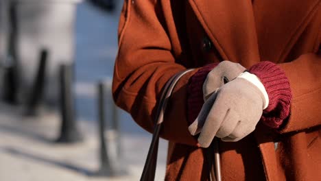 woman in a brown coat wearing gloves