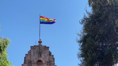 la bandera del arco iris inka de cusco peru sopla en el viento en un día de cielo azul