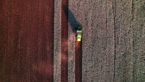 epic top down aerial of a green combine harvester collecting cotton, showcasing modern agriculture