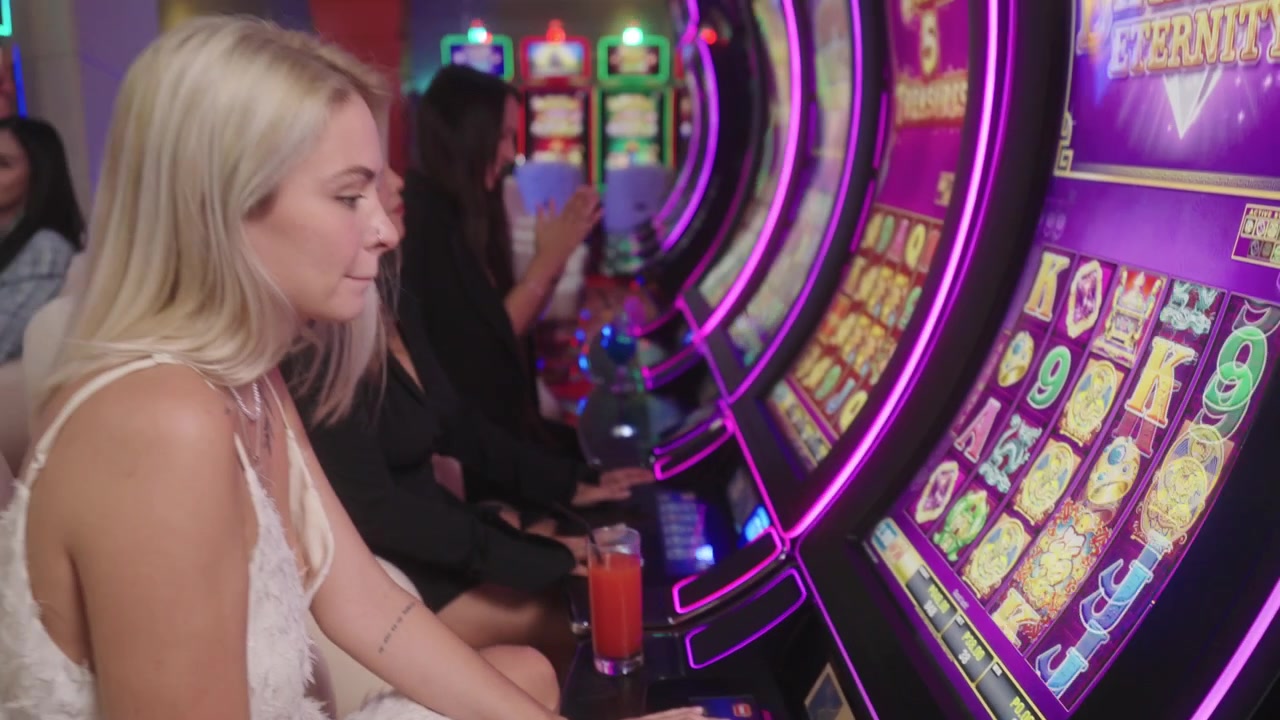 Filmato cinematografico di casinò con un gruppo di donne che socializzano divertendosi attorno a una macchina da gioco elettronica