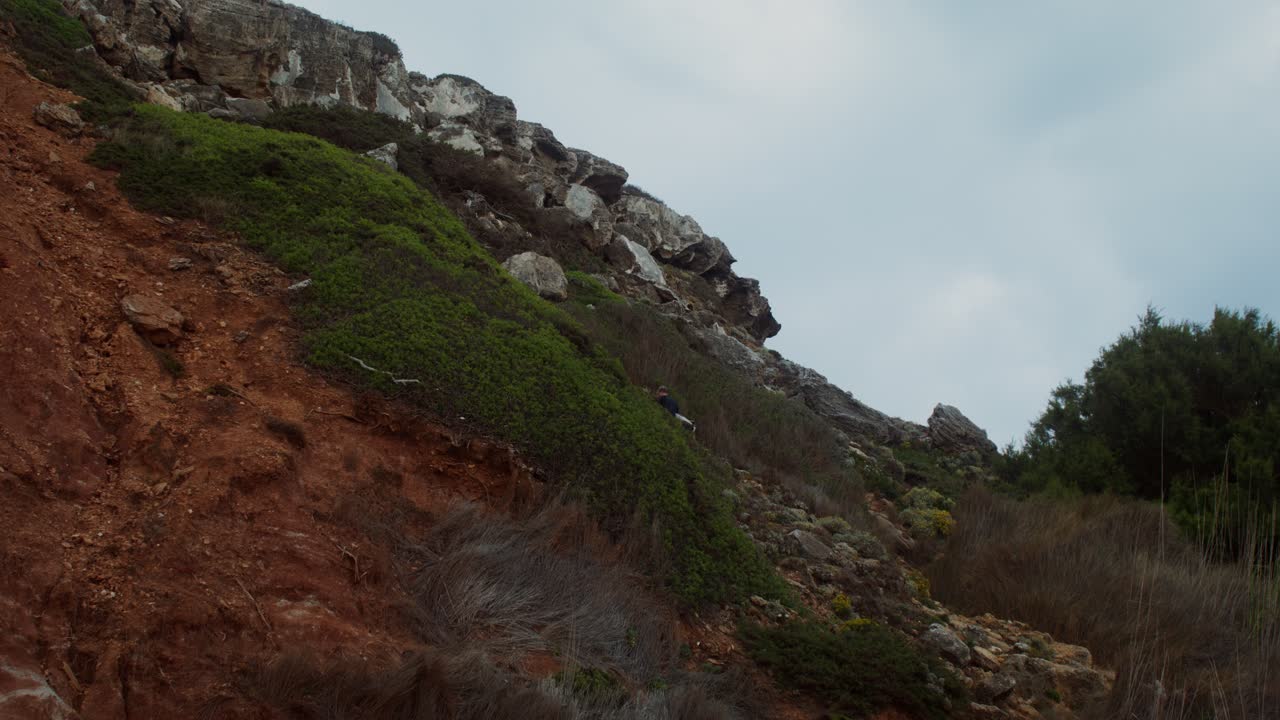 persona escalando un acantilado rocoso