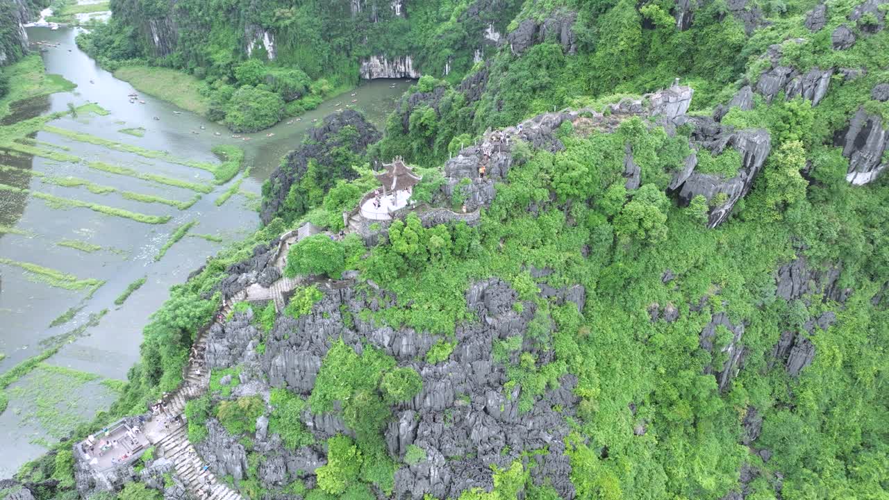 Ancient stone stairs and dragon statue atop lush mountain in Ninh Binh, Vietnam