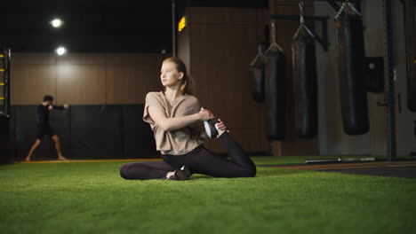 Eifrige-Boxerin-Beim-Stretching-Im-Fitnessstudio.-Fitte-Frau-Trainiert-Im-Sportverein