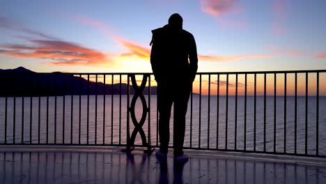 Beautiful-silhouetted-viewpoint-over-ocean-during-vibrant-sunset