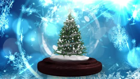 Animation-of-decorated-christmas-tree-in-snow-globe,-with-falling-snowflakes-and-lights,-on-blue