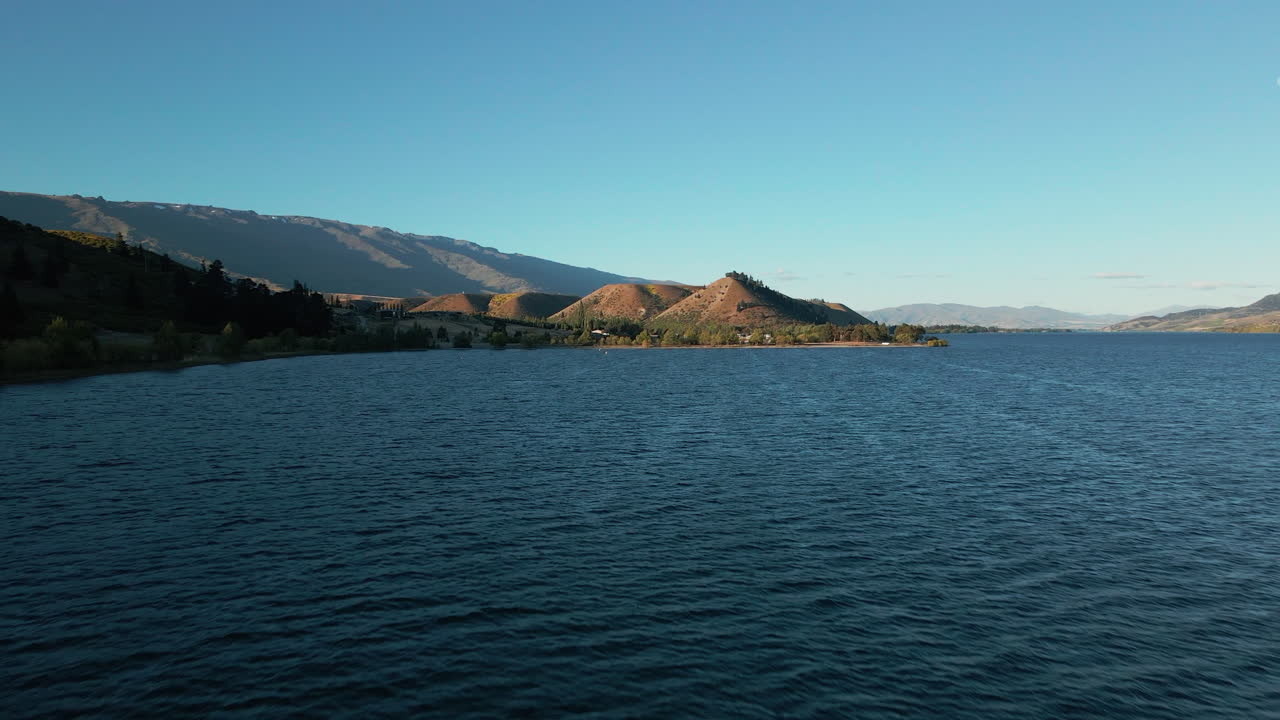 ancho río azul clutha con exuberantes colinas verdes en la orilla del río