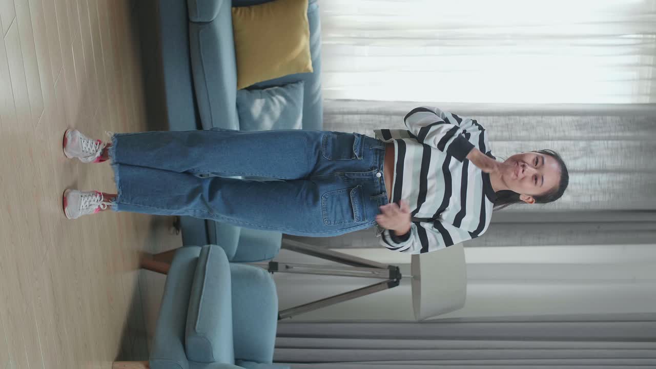 Full Body Of Asian Woman Dancing While Shooting Video Content For Social Networks At Home