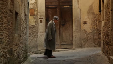 elderly man walking in a historic stone alley