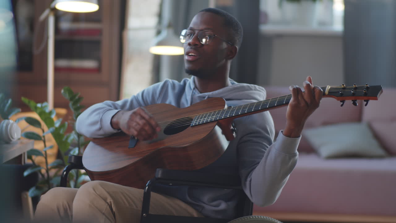 Mand i kørestol synger og spiller guitar