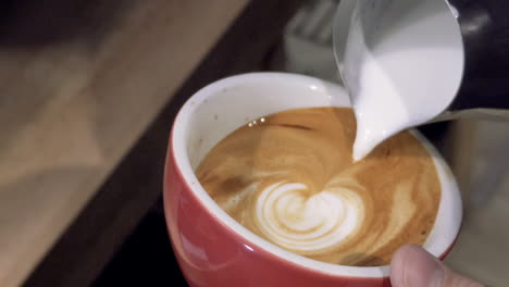 barista carefully pouring latte art