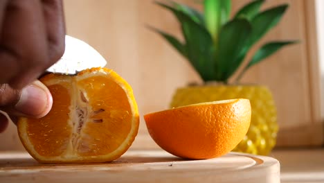 cortando una naranja en una tabla de madera