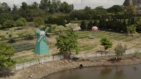 decorative holland style windmill in a formal park next to small lake