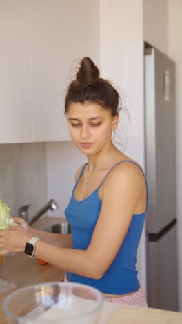 mujer preparando una ensalada en su cocina