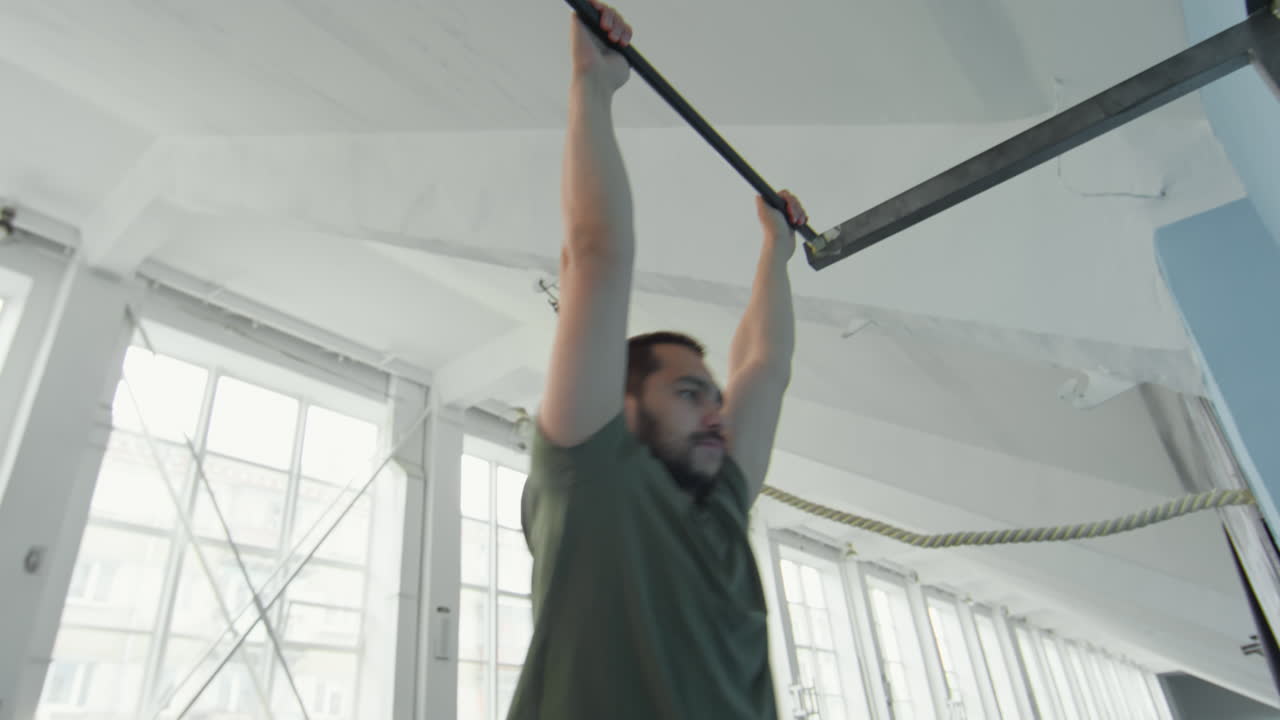 Sportsman with Prosthetic Leg Doing Hanging Leg Raise on Bar