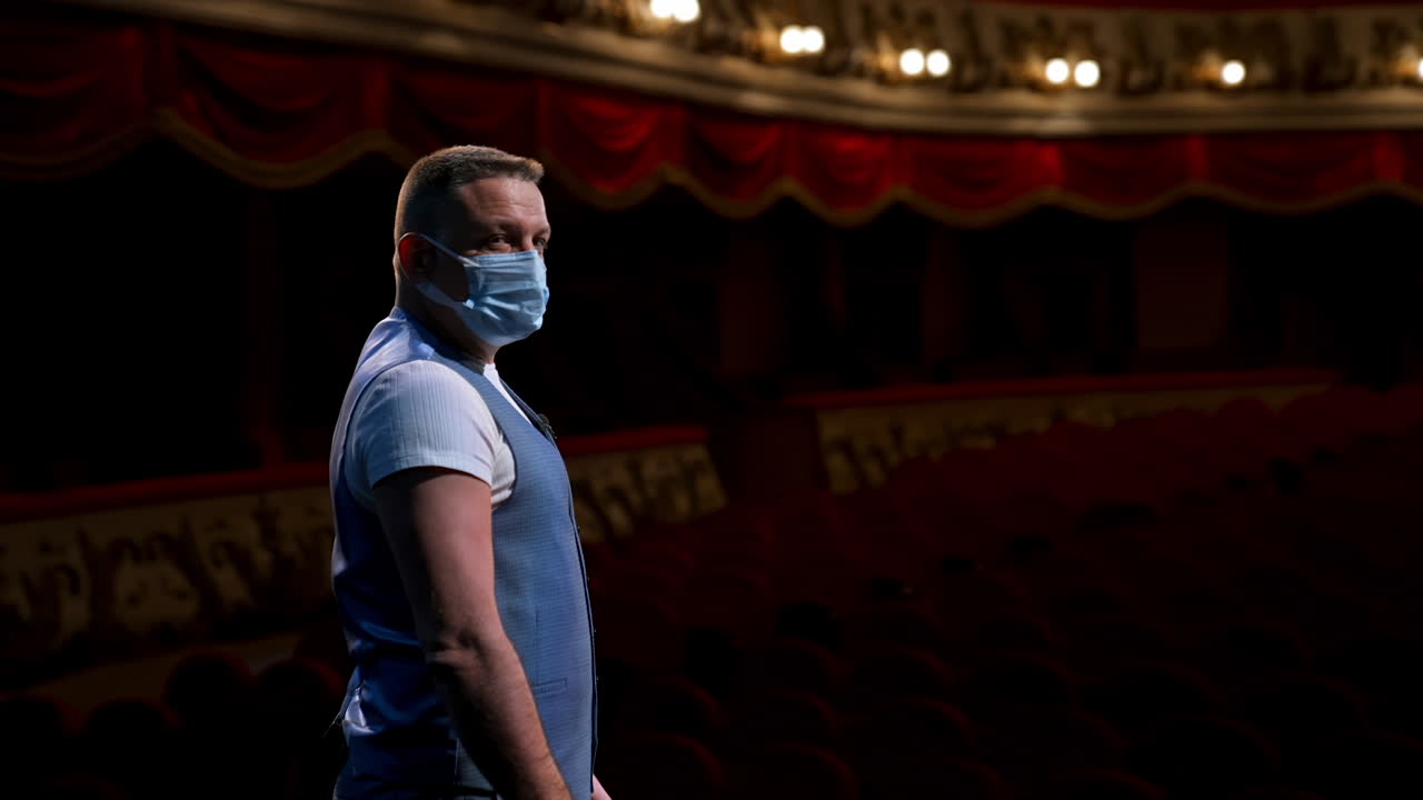 Man in mask at theatre. Man in protective face mask performs on stage