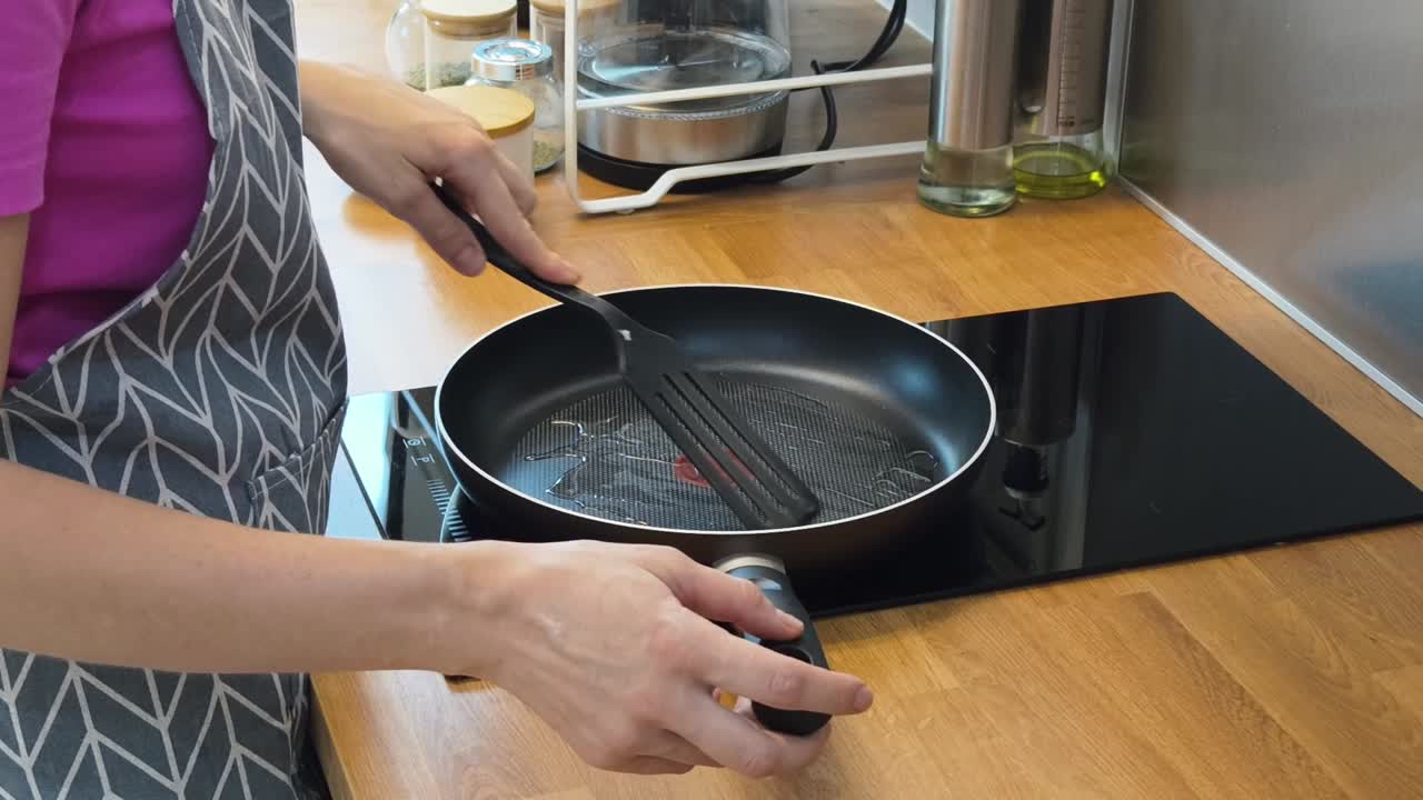 mujer cocinando con una sartén en la estufa