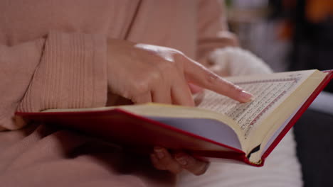 primer plano de una mujer musulmana sentada en el sofá en casa leyendo o estudiando el corán 7