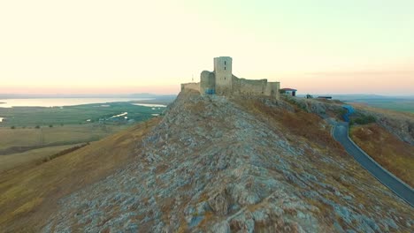 Fortaleza-De-Enisala-En-Rumania,-Disparo-De-Drones,-Volando-Hacia-La-Fortaleza-Al-Atardecer