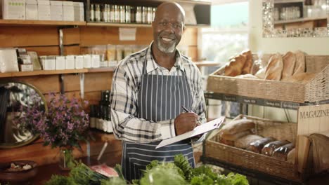 feliz anciano afroamericano dueño de una tienda haciendo inventario en una tienda de alimentos saludables, cámara lenta