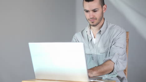 un hombre se sienta en una computadora, escribe algo, sonríe, se levanta y se va