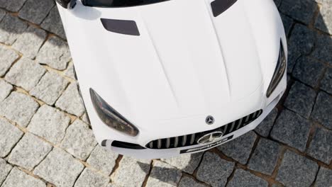white miniature mercedes toy car on cobblestone pavement, viewed from above