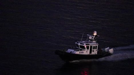 overhead view of harbor patrol driving at full speed at night