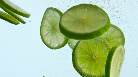cal verde fresco bajo el agua sobre un fondo blanco de cerca. agua flotante de cítricos