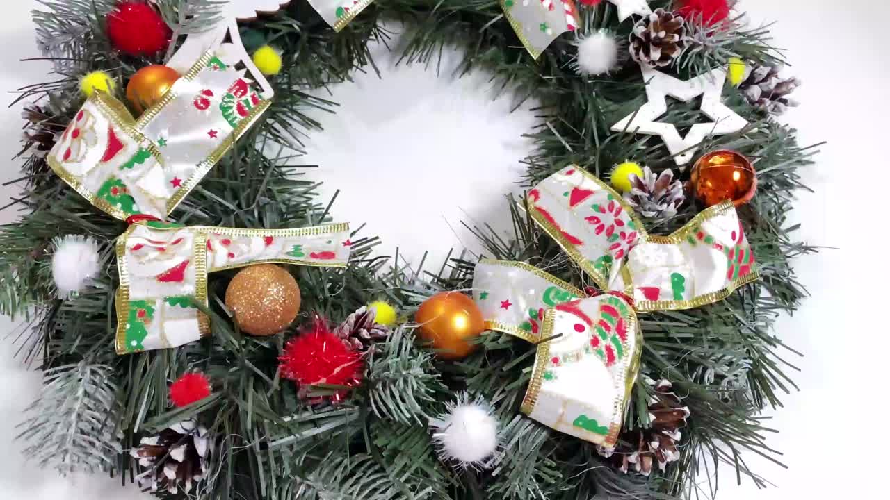 크리스마스 문 앞을 장식하는 크리스마스 꽃받침은 색 배경에 고립 된 스프루스, 은 활, 별 및 크리스마스 공으로 만들어졌습니다.