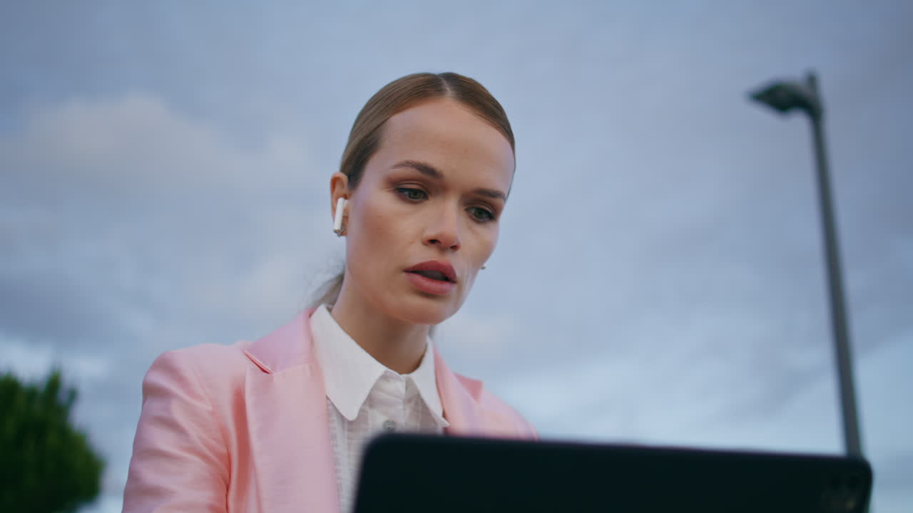 онлайн-спикер говорит ноутбук камера сидит на открытом воздухе в наушниках близко.