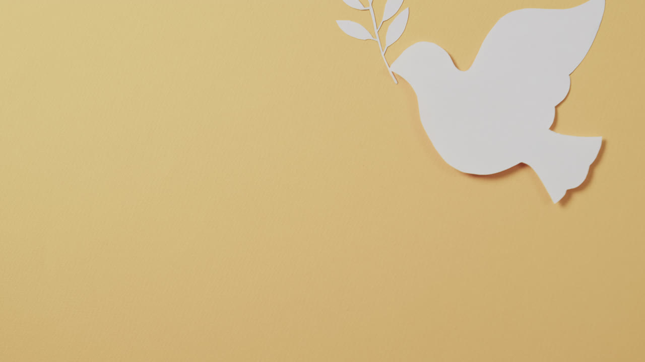 primer plano de paloma blanca con hoja y espacio de copia en fondo amarillo