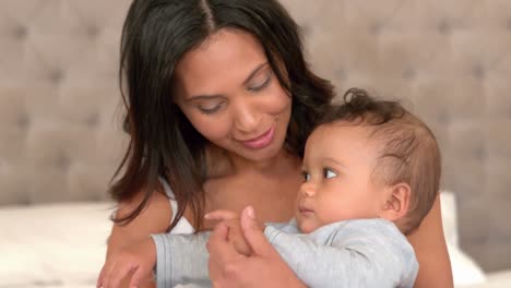 Mutter-Mit-Süßem-Baby-Sitzt-Auf-Dem-Bett