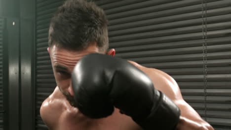 hombre en forma golpeando con guantes de boxeo