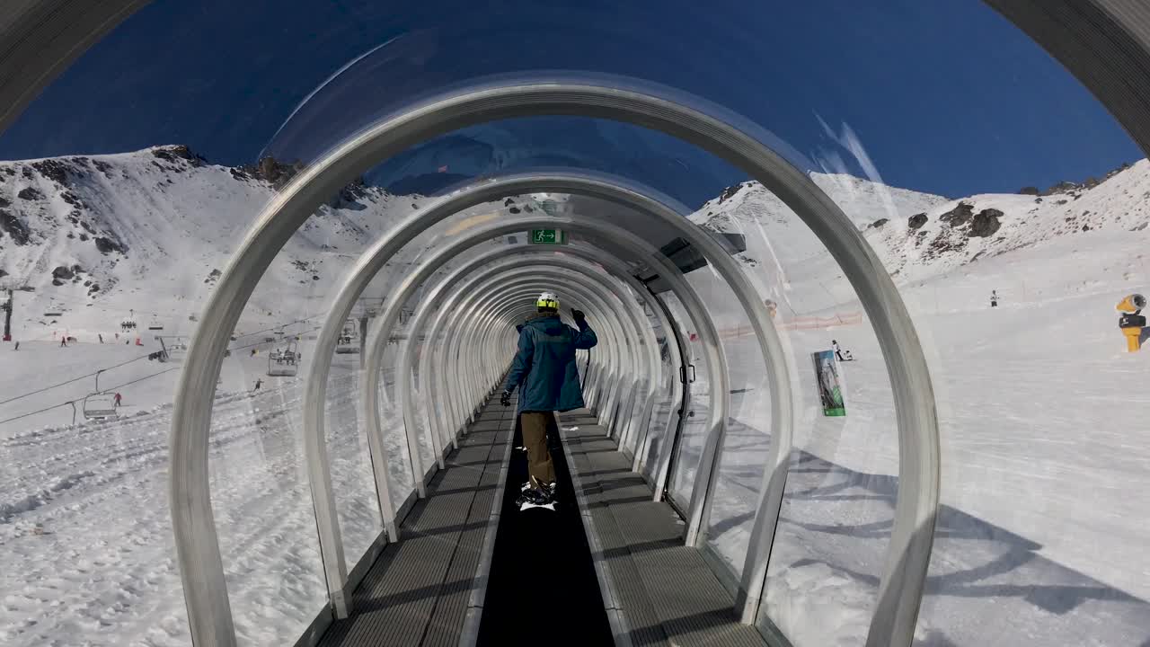 мужчина поднимается по горнолыжному конвейеру "волшебный ковер" в зоне катания "ремаркаблс", квинстаун, новая зеландия