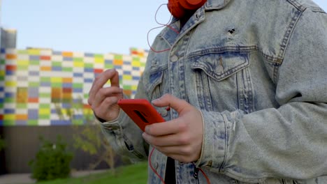 reproducir música en el teléfono celular rojo y chasquear los dedos al ritmo