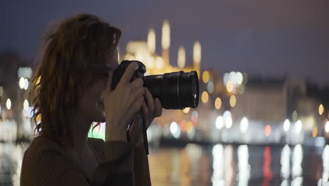 woman photographing istanbul at night