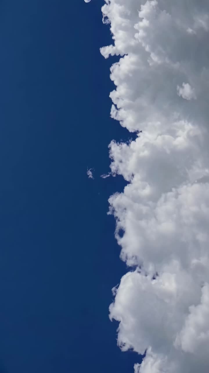 Aerial video angle capturing fluffy white clouds against a deep blue sky, creating a serene