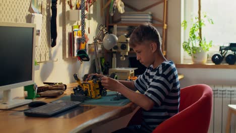 boy building a toy robot at a desk