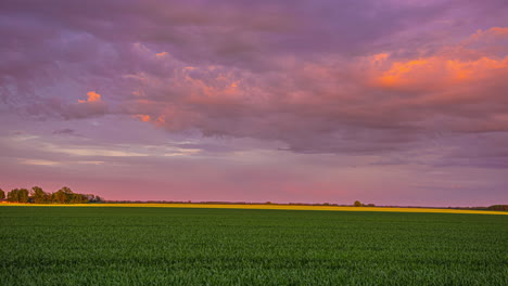 Tiro-De-Lapso-De-Tiempo-Del-Campo-Agrícola-Idílico-Y-Nubes-En-Movimiento-En-El-Cielo-Colorido-Después-De-La-Puesta-Del-Sol---Material-De-Archivo-De-5k