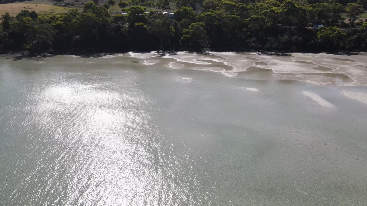 panorámica aérea de drones sobre aguas claras y playas de arena en tasmania