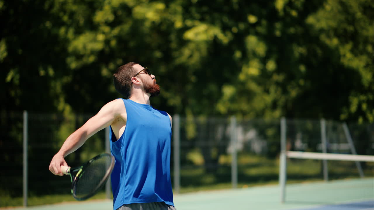 Two men playing tennis on a blue and green court on a sunny day