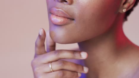 African-american-woman-with-short-dark-hair-in-blue-and-pink-light-with-copy-space,-slow-motion