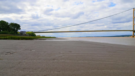 Aerial-drone-captures-Humber-Bridge,-12th-largest-suspension-span,-over-River-Humber,-connecting-Lincolnshire-to-Humberside-amid-traffic