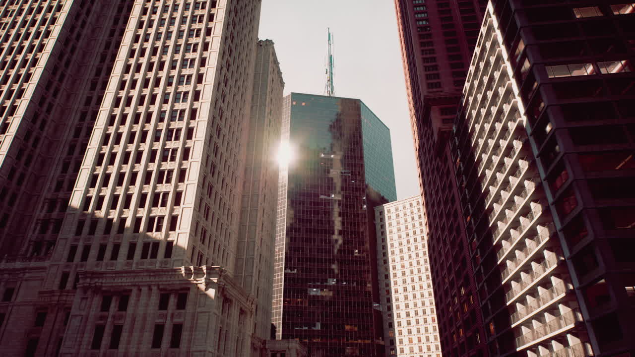 Tall buildings tower against a clear sky in a bustling downtown area