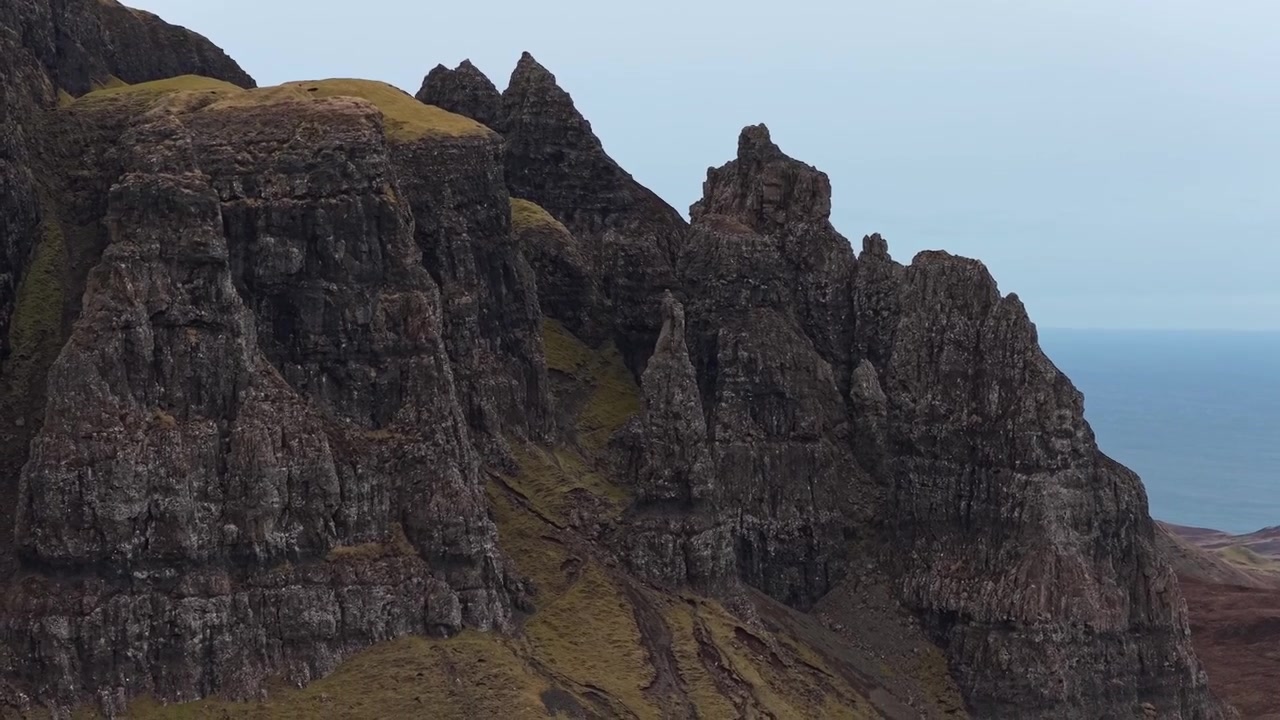 Letecký pohled klesající podél rozeklaných a dramatických čedičových skalních útvarů Quiraingu na ostrově Skye ve Skotsku.