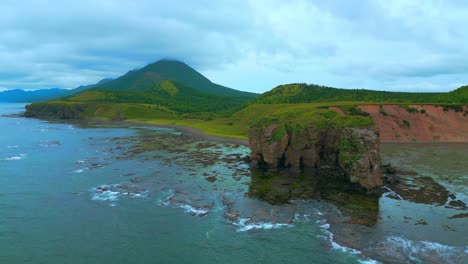 coastal landscape with rocky island and mountains