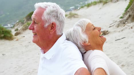 senior couple standing back to back with arms outstretched