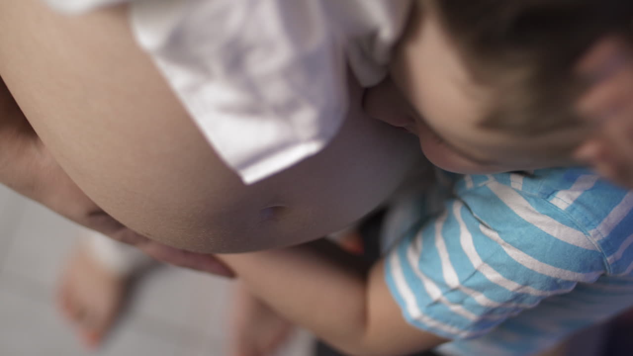 사랑하고 조심스러운 아들과 임신 중인 어머니